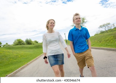 A Summer Portrait Of Mother And Son Outside On A Road