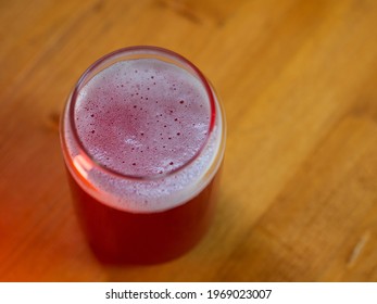 Summer Red Fruit Craft Beer Sour Ale. Stylish Glass In The Form Of A Can Of Beer. Wooden Table