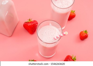 Summer refreshing desserts and calcium rich healthy drink concept theme with glasses of strawberry milk, glass bottle, striped straws and scattered strawberries isolated on pink background - Powered by Shutterstock