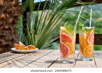 Summer refreshing lemonade drink with grapefruit, lemon, orange slices and mint. Fresh healthy cold citrus beverage. Citrus fruit infused water. - Powered by Shutterstock