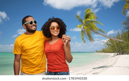 summer, relationships and people concept - happy african american couple in sunglasses over tropical beach background in french polynesia