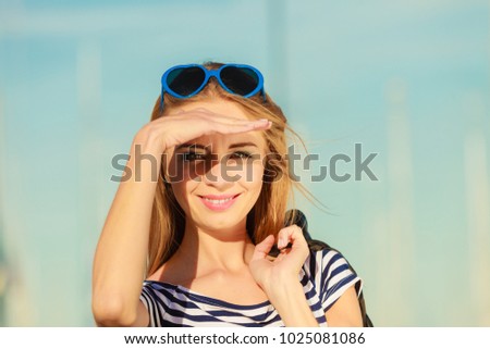 Summer relaxation concept.. Portrait girl with blue heart shaped sunglasses enjoying summer breeze outdoor in marina
