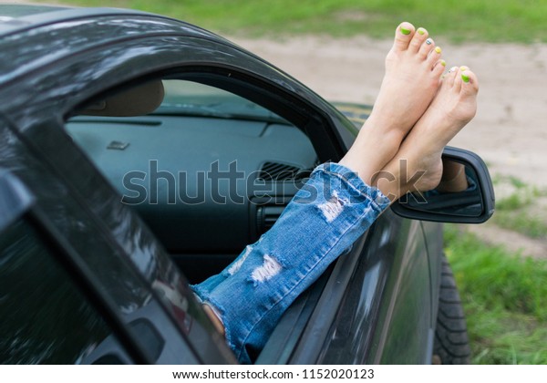 Summer\
road trip car vacation concept. Woman legs out the windows in car.\
Conceptual freedom, travel and holidays\
image.