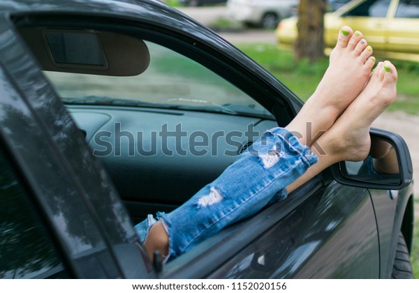Summer\
road trip car vacation concept. Woman legs out the windows in car.\
Conceptual freedom, travel and holidays\
image.