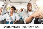 Summer Road Trip. Happy Black Family Of Three Riding Car And Singing Having Fun Traveling By Automobile. Parents And Daughter Enjoying Auto Ride Together On Weekend. Panorama, Selective Focus