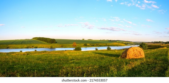 Summer Rural Landscape With Hay Bale And Calm River In Sunny June Morning