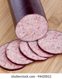 Summer Sausage Sliced On A Cutting Board.