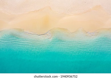 Summer seascape beautiful waves, blue sea water in sunny day. Top view from drone. Sea aerial view, amazing tropical nature background. Beautiful bright sea with waves splashing and beach sand concept
