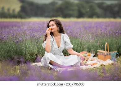 The summer season.Lavender fields. A girl on a picnic in the flowering fields