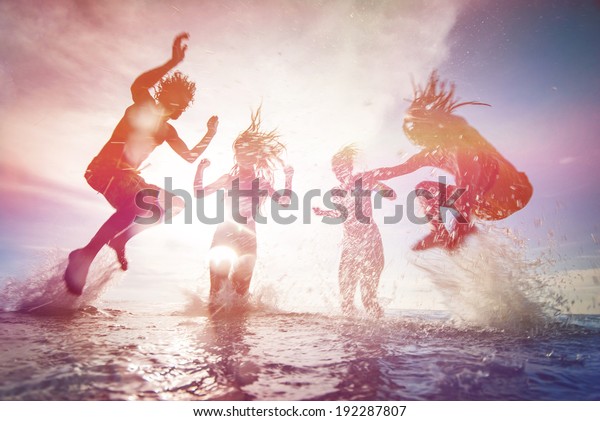 夏は、幸せな若者が海で跳び上がる姿が写真で浮かび上がります。ソフトフォーカスと太陽のフレアを持つビンテージレトロスタイル
