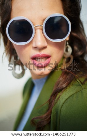 Summer spring fashion. Vertical portrait of woman wearing trendy sunglasses and modern suit.