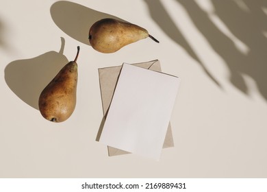 Summer Still Life Composition. Autumn Weddding Greeting Card, Envelope Mock Up Scene. Two Pears Fruit, Long Harsh Shadows Overlay. Beige Table Background In Sunlight. Flat Lay, Top View, No People.