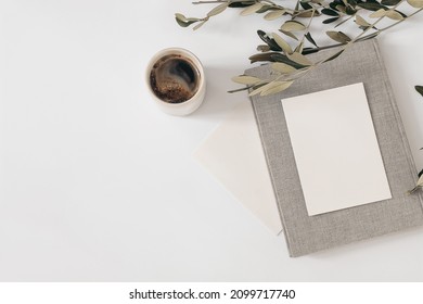 Summer Still Life. Cup Of Coffee, Blank Greeting Card Mockups With Vintage Book. Olive Tree Branch Isolated On White Table Background. Mediterranean Wedding Stationery. Flat Lay, Top View. Breakfast.