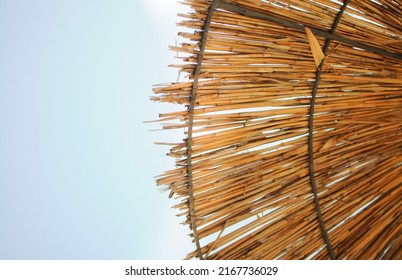 Summer straw beach umbrellas on the blue sky copy space - Powered by Shutterstock