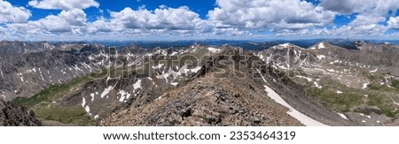 Summer Summit View - A panoramic view of white clouds rolling over rugged high mountain peaks at Continental Divide, as seen at summit of Quandary Peak, on a sunny Summer day. Colorado, USA.