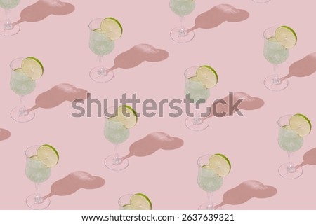 Summer sunlight pattern made of green tropical refreshing drink with lime slice on pastel pink background. Minimal cocktail concept. Trendy summertime party backdrop idea.
