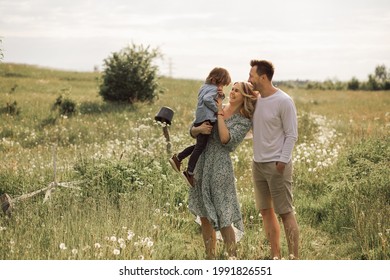 Summer sunny day for a young family, dad, mom and little son became joyful and happy. Beautiful flower meadow, happy family concept photo