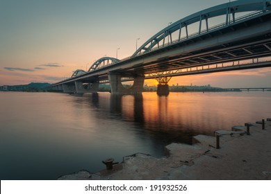 Summer sunset on the riverbank. City bridges over the river Dniepr. Kiev. Ukraine.