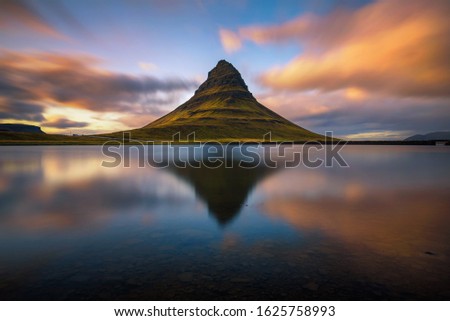 Summer sunset over the famous Kirkjufell mountain with reflection in a nearby lake in Iceland. Long exposure.