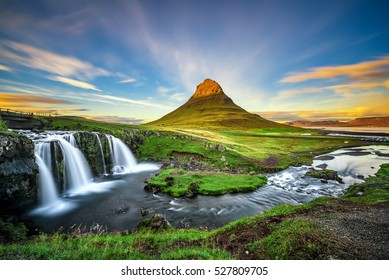 Summer sunset over the famous Kirkjufellsfoss Waterfall with Kirkjufell mountain in the background in Iceland. Long exposure.