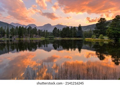Summer Sunset at Sprague Lake - A panoramic Summer sunset view at Sprague Lake, with high peaks of Continental Divide rising at shore, Rocky Mountain National Park, Colorado, USA.