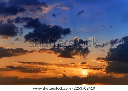 Summer sunset. Storm clouds on the background of the orange sky. Abstract natural background.