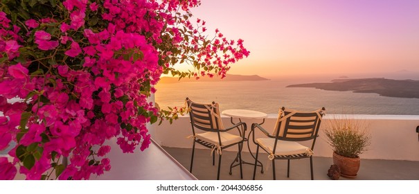 Summer Sunset Vacation Scenic Of Luxury Famous Europe Destination. White Architecture In Santorini, Greece. Stunning Travel Scenery With Pink Flowers Chairs, Terrace Sunny Blue Sky. Romantic Street