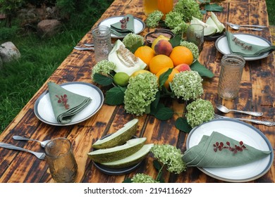 Summer Table Set. Outdoor Dining. Table Decorated Fresh Flowers And Fruits.