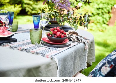 summer table setting in the garden in green and red palette with berries - Powered by Shutterstock