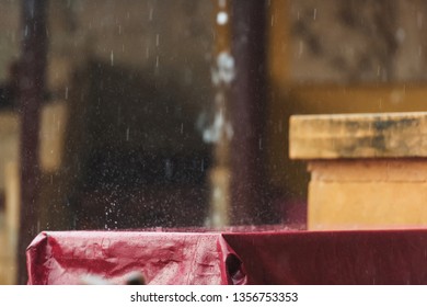 Summer Terrace Of The Restaurant In The Rain. Wet The Table With A Burgundy Tablecloth. A Spray Of Water. Rainy Weather.