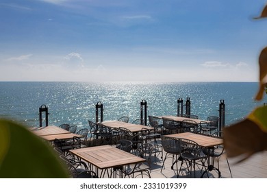 Summer terrace with stylish trendy outdoor furniture at a luxurious travel destination. Wooden desk of free space and summer background of beach. - Shutterstock ID 2331019399