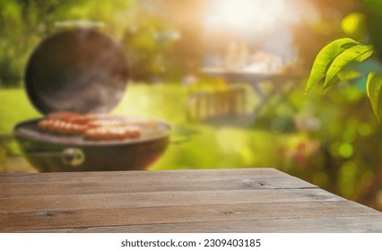 summer time in backyard garden with grill BBQ, wooden table, blurred background - Shutterstock ID 2309403185