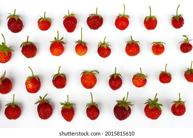 Summer time. The berries of ripe, juicy and eco-friendly strawberries with green stems lie in even rows on a white background.A pattern of red garden berries. Cooking,drinks,design.template,background