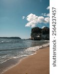 Summer time at Cathedral Cove on the Coromandel Peninsula in New Zealand. An iconic location for New Zealand summers with its iconic archway cave, rock formations, blue waters and golden sand.