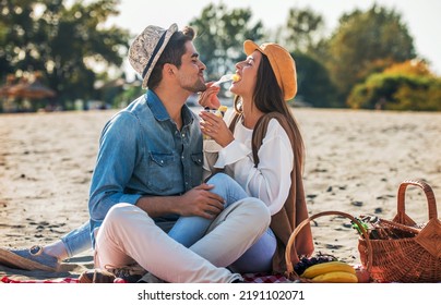 Summer time. Happy young couple enjoying in a good mood and picnic day on the beach. Lifestyle, love, dating, vacation concept - Powered by Shutterstock