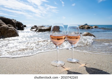 Summer time in Provence, two glasses of cold rose wine on sandy beach near Saint-Tropez in sunny day, Var department, France