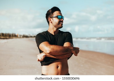 Summer Time. Smiling Man Taking Off His Shirt At The Beach