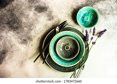 Summer time table set with ceramic plates and modern metal cutlery served for dinner and decorated with lavender flowers