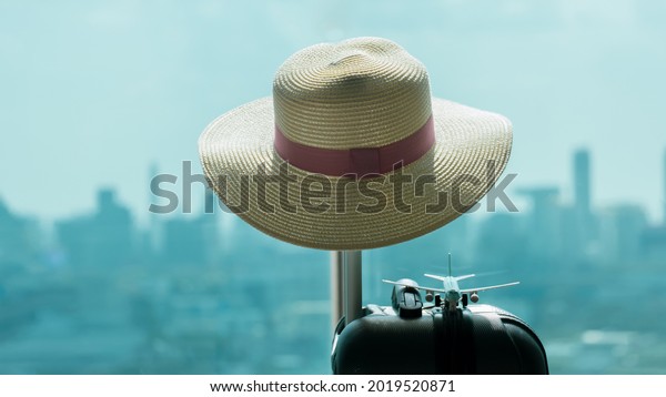 Summer time\
-Travel bag and straw hat. room in hotel  at Central Business\
District, suitcase with travel accessories. preparation of vacation\
concept. ready for travel, travel\
abroad,