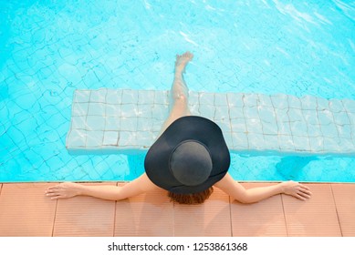 Summer time and Vacations. Women lifestyle relaxing and happy near luxury swimming pool sunbath, summer day at the beach resort in the hotel. Summer Concept 