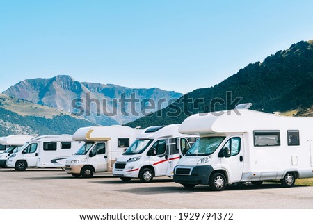 Summer tourism with RV in the mountain. Campers parked in a row in a caravan parking area. Best option for travel. Motorhomes and campingcar.