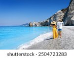 A summer tourist couple walks down the beautiful beach of Lalaria at Skiathos island, Sporades, Greece