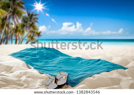 Summer towel on sand. Beach background with palms and ocean. Free space for your decoration. 