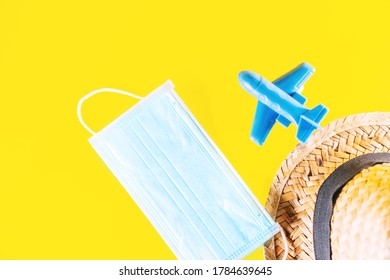 Summer Travel 2020 During The Coronavirus Pandemic. Holiday Kit To Prevent Covid 19 Infection. New Normal Preparation For Vacations To Travel Safely. Medical Face Mask, Straw Hat And Plane.