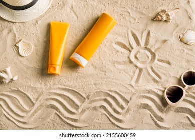 Summer travel beach flat lay composition. Wicker hat, sunglasses, sunscreen lotion, sunblock cream and seashells on beach sand background. Summer vacations and spf uv-protecting skin care concept.