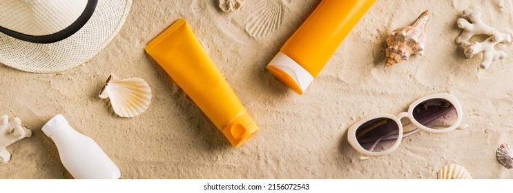 Summer travel beach flat lay composition, banner. Hat, sunglasses, sunscreen lotion, sunblock cream on beach sand background. Summer vacations and spf uv-protecting skin care concept. - Shutterstock ID 2156072543