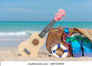 Summer Travel. Bikini and Flip-flops ,hat, ukulele, and bag near beach chair on sandy beach against blue sea and sky background, copy space. Summer vacation concept. - Powered by Shutterstock