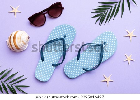 Summer travel concept. Flip flops, sunglasses and starfish on white. Top view on colored background.
