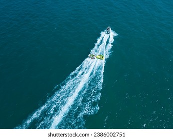 Summer travel vacation concept. eople ride on banana boat. Bright blue sea and clear sky. Happy vacation. Beach water sport