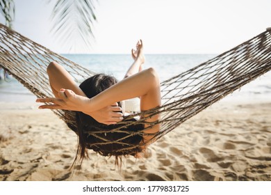 Summer travel vacation concept, Happy traveler asian woman with white bikini relax in hammock on beach in Koh mak, Thailand - Shutterstock ID 1779831725
